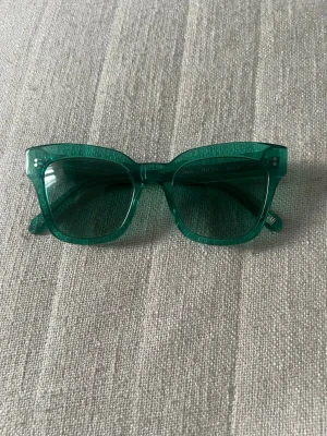 Chimi 04 limited edition - Snygga solglasögon med transparent grön båge och matchande gröna glas. Modellen har en trendig, fyrkantig form som ger en cool retrovibe. Nyskick, tyvärr utan adsk