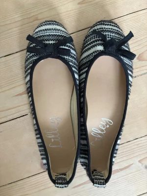 Randiga ballerinaskor från Lilley - Snygga ballerinaskor från Lilley med svart vit randigt mönster. I storlek 37-38💗
