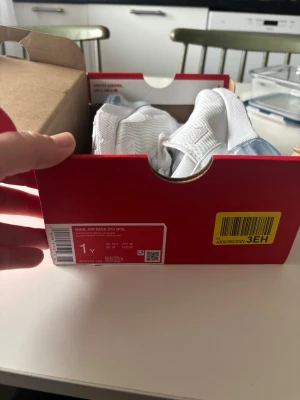 Nike Air Max 270 vita sneakers stl 32 - Nike Air Max 270 sneakers i helvitt med mesh-överdel och synlig Air Max-dämpning i hälen. Snygg och sportig design med vita detaljer och klassisk Nike-logga på sidan. Perfekta för dig som gillar en clean och modern look.