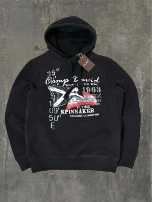 Svart hoodie Archive - Tagg finns ej längre. Cool svart hoodie Archive med stor grafisk print på bröstet i vitt, grått och rött. Hoodien har huva med snören och ribbade muddar. Perfekt för dig som gillar en sportig och avslappnad stil. Materialet känns mjukt och bekvämt.