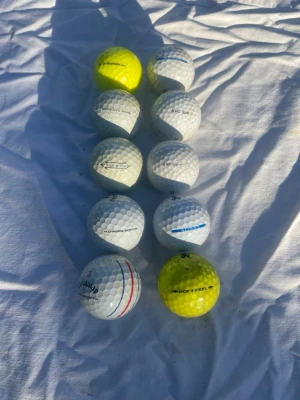 10 st lite finare gilfbollar - Säljer ett set med tio golfbollar i olika märken och modeller. Bollarna är både vita och gula, med klassisk rund form och dimpled yta. Perfekt för dig som vill fylla på golfbagen med blandade bollar till träning eller spel. 
