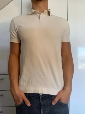 Vit piké från These glory days - Vit piké i 100% bomull. Strl S. Inga defekter. Modellen är 178 cm och väger 77 kg. Hör gärna av dig vid frågor!