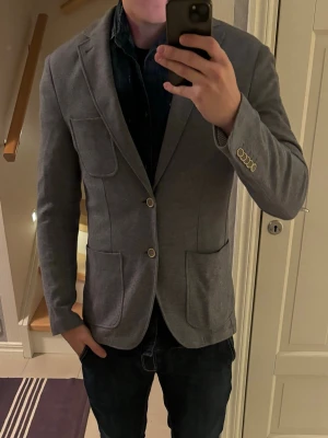 Otrolig grym Riley kavaj/cardigan i 50 - En helt otrolig sjukt schysst grå glänsande Riley kavajjacka i storlek 50. Utmärkt skick som ny och perfekt att använda som cardigan eller jacka nu till sommaren. Perfekt för alla tillfällen och grym passform! Tveka inte vid minsta fråga eller fundering.