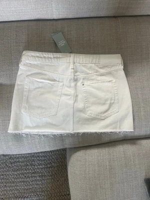 Helt Oanvänd Vit jeanskjol - Lågmidjad vit jeans kjol som är helt oanvänd. Prislappen sitter fortfarande kvar! Jeanskjolen är i storleken M och har inga defekter alls då den aldrig är använd. Bara höra av er vid frågor💞💞