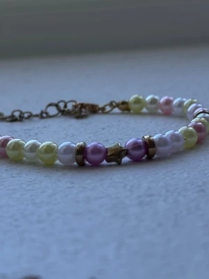 Handmade bracelet - This is a handmade bracelet by myself, with yellow, white, purple and pink pearls. It has gold beads between some and a star. Beautiful bracelet to wear whenever, with an adjustable part so you can make it bigger or smaller. Check out my profile for more handmade pieces 🌸