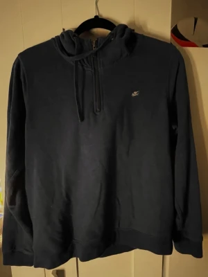 Mörkblå hoodie från New Yorker - Mörkblå hoodie från New Yorker med dragkedja vid halsen . Hoodien har en klassisk huva och ribbade muddar vid ärmslut och nederkant. Tillverkad i mjukt material som känns skönt mot huden. Storleken är L men jag skulle säga att den passar S/M