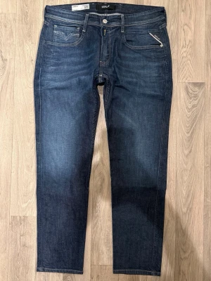 Replay Anbass Jeans Mörkblå W33/L30 - Helt Nya Slim Fit - Replay Anbass mörkblå jeans i stretchig denim med slim fit passform som sitter snyggt och bekvämt och funkar till allt, helt nya (utan tags), storlek W33/L30, midja 43,5 cm, ytterbenslängd 98 cm, benöppning 17 cm, modellen är 185cm & väger 65kg, i nyskick.