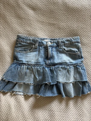 Blå jeanskjol med volanger - Trendig blå jeanskjol med två lager volanger. Kort och lågmidjad från gina. För liten för mig tyvärr💕💕Passar person med xs