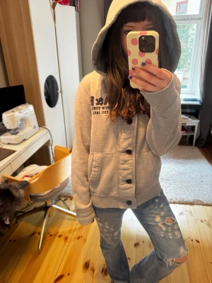 Grå hoodie från Abercrombie & Fitch - Grå hoodie med knappar framtill från Abercrombie & Fitch. Jättemysig och snygg, lite oversized🫰🏻det står xlarge men passar bra på mig som är S (bild)❤️ en slitning på höger armbåge men annars jättebra skick!