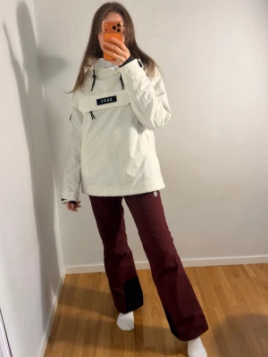 Skidbyxor  - Säljer ett par vinröda täckbyxor från 8848 med svarta förstärkningar vid bensluten och justerbara hängslen. Byxorna har rak passform och är perfekta för vinterns alla äventyr. Snygg och funktionell design som håller dig varm och torr. Oanvända. Bra längd, jag är 170 .