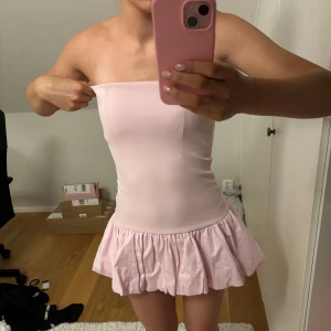 Ljusrosa klänning  - Supersöt ljusrosa kort klänning från Zara med volangig kjol. Klänningen har en dragkedja i sidan men har tyvärr ett litet hår längst ner vid den. Köpte för ca 400kr 3 månader sen. Använd 3 gånger! 