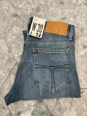 Tiger of Sweden jeans - Hej, säljer ett par blå Tiger of Sweden jeans i oanvänt skick. Jeansen har kvar prislappen och har aldrig används. Storlek: W30, L34. Hör av dig om du vill ha fler bilder, eller bara har frågor att ställa(inga är för dumma)!🙌// Milo. 