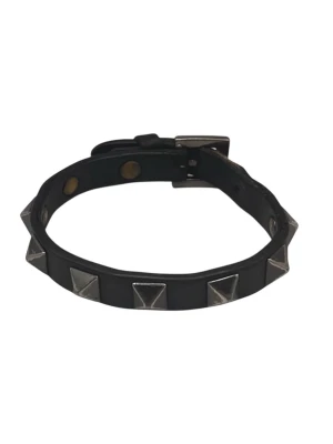 Svart läderarmband med nitar från valentino - Coolt svart armband i läder med silverfärgade pyramidformade nitar runt om. Justerbart spänne för perfekt passform. Perfekt accessoar för en edgy och trendig stil.
