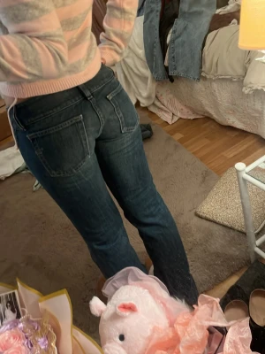 Diesel raka jeans med fickor - Säljer ett par mörkblå jeans med raka ben och stora fickor både fram och bak. Jeansen har dubbla knappar i midjan och klassisk femficksdesign. Perfekta till en avslappnad och trendig look.