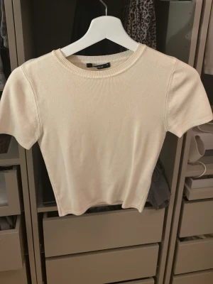 Ljusbeige ribbad topp från Bik Bok - Säljer en ljusbeige ribbad topp från Bik Bok med rund halsringning. Materialet känns mjukt och stretchigt för en bekväm passform.💞💞