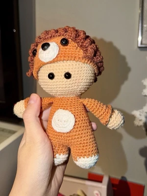 Virkad docka  - Handgjort virkat maskeradset i form av ett lejon, med brunt lockigt hår, beige ansikte och kropp i orange och vitt. Dräkten har ett gulligt lejonansikte på huvan. Virkad med bomullsgarn.