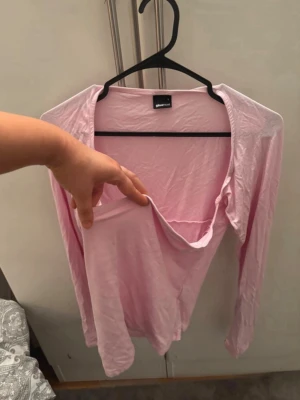 Ljusrosa omlottopp från Gina Tricot - Supersöt ljusrosa omlottopp från Gina Tricot med lång ärm och djup v-ringning. Tunn och mjuk i materialet, perfekt att styla med jeans eller kjol. Enkel men trendig design som passar till många olika looks. För mer bilder/justering av pris skriv gärna❤️🤗