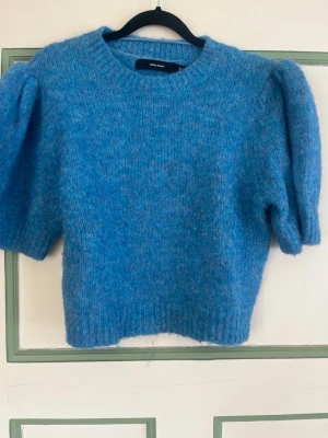 Blå fluffig stickad tröja - Mysig stickad tröja i en klarblå färg med fluffig känsla. Tröjan har rund halsringning och långa ärmar. Perfekt för att hålla värmen under kyliga dagar. 