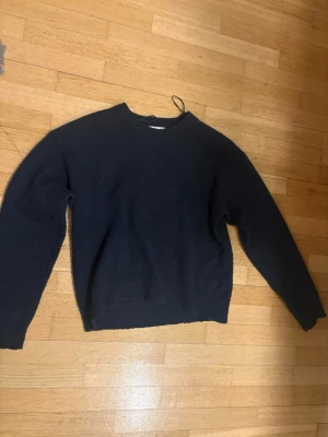 Mörkblå stickad tröja - En enkel och stilren mörkblå stickad tröja med rund halsringning och långa ärmar. Tröjan har ribbstickade muddar vid ärmslut och nederkant. Perfekt för lager på lager och passar till det mesta i garderoben. Storlek 158/164 men passar xs. Priset går att diskutera. Frakt ingår ej! Har blivit lite nopprig.
