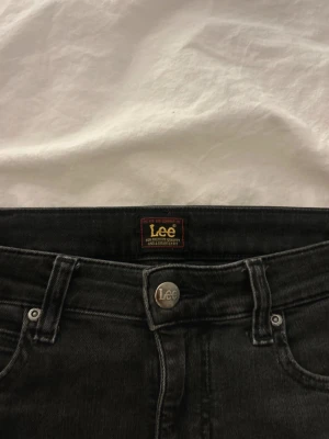 Svarta lowwaist jeans från Lee - Säljer ett par svarta lowwaist jeans från Lee. Jeansen har klassisk femficksdesign, Lee-logga på bakfickan och är tillverkade i stretchigt denimtyg för skön passform. Perfekta till en avslappnad och trendig look. Pris kan diskuteras💕