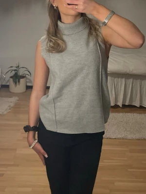 Grå ärmlös stickad polotopp - Superfin grå polo från Zara! Detaljer på framsidan. Kommer tyvärr inte till användning💫 storlek S men passar även XS