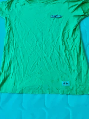 t-shirt med Los Angeles-tryck - Gul t-shirt från 157 med ett litet Los Angeles-tryck på bröstet. T-shirten är i 100% bomull och har klassisk rund hals och korta ärmar. Perfekt för en avslappnad och cool stil.