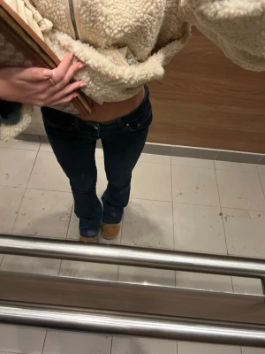 Mörkblå bootcut leggings - Säljer ett par mörkblå leggings med bootcut-modell och låg midja. De har klassisk femficksdesign och är stretchiga för en bekväm passform. Perfekta till sneakers eller boots för en avslappnad look.