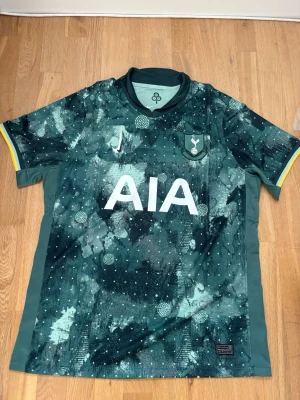 Tottenham Hotspur bortatröja Nike - Snygg Tottenham Hotspur bortatröja från Nike i grönt och svart med abstrakt mönster, vita detaljer och klubbmärke på bröstet. Kom med frågor, pris går att diskuteras. Passar Xl