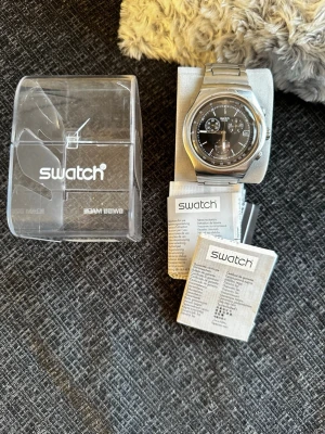 Swatch Irony Chronograph klocka - Säljer min Swatch Irony kronograf i rostfritt stål. Klockan är i mycket fint / nyskick och har knappt använts. Levereras komplett med originalbox och manualer.  Alla funktioner är i ordning, men batteriet är slut och behöver bytas (enkelt och billigt hos urmakare eller Swatch-butik).