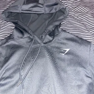 Gymshark hoodie🏋️ - Riktigt skön gymshark hoodie i perfekt skick. Materialet är bekvämt och andas vilket gör att den är skön att bära. Modellen är lite mer avlång än andra vilket gör att du lättare kan utföra vissa rörelser. Säljes på grund av att den är blivit för liten.