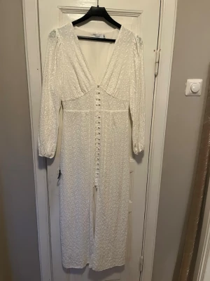 Vit klänning  - Vit klänning med blom mönster . Klädda knappar . Fattas dock tre stycken (se bild) inget som stört mig , men kan enkelt sy i nya . Nypris 900kr. Använd ett fåtal gånger 
