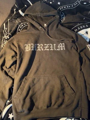 Burzum hoodie - Svart hoodie med stor Burzum-logga i grå gotisk stil på bröstet och vit burzum logga på båda ärmarna. Klassisk känguruficka framtill och justerbar huva med snören. Tillverkad i mjukt bomullsmaterial, perfekt för dig som gillar metal 🤘Kommer sätta ett ganska högt pris då jag sätt dessa typer av hoodies gå för ganska stora summor (enligt mig) men priset går absolut att diskutera🖤