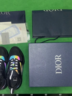 Dior sneakers  - Säljer ett par svarta Dior sneakers med mesh och läder, prydda med färgglada regnbågsdetaljer på sidorna och ovandelen. Skorna har en chunky sula och tydlig Dior-logga på sidan och plösen. Perfekta för dig som vill sticka ut med exklusiv streetstyle.