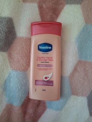 Vaseline handkräm för starkare naglar - Handkräm från Vaseline som stärker naglar och återfuktar händer. Innehåller hydrolyserat keratin, ultra återfuktande lipider och Vaseline jelly. Kommer i en rosa plastflaska med röd kork och rymmer 200 ml. Perfekt för dig som vill ha mjuka händer och starkare naglar. 70% av 100% använt. Jag erbjuder denna kräm tills den 19 Juli. 