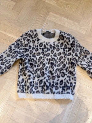 Leopardmönstrad stickad tröja Zara - Säljer en fluffig och mysig stickad tröja från Zara i storlek S med leopardmönster i beige, brunt och svart🐆