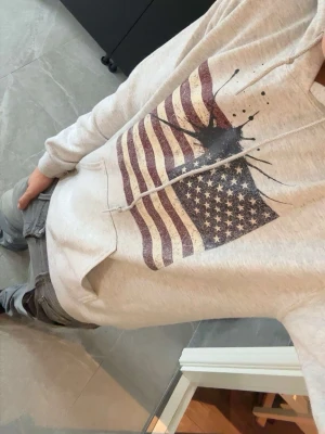 Grå hoodie med USA-flagga ink - Säljer en grå hoodie med tryck av amerikanska flaggan och en ink splash tröjan är grå Concrete ink skriv vid fundering eller fråga 🚨pris går att diskutera 