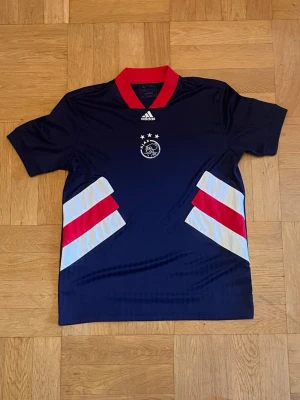 Ajax - Sjukt snygg Ajax tröja icon edition tröja från säsongen 22-23, köptes 2023 och andvänds en gång sen dess helt perfekt skick. Tröjan passar väldigt stort och kan passa perfekt för dig som bär storlek M men till och med L eftersom den har väldigt stretchigt material. Storleken är inte en effekt som kommit från något externt utan den köptes så.
