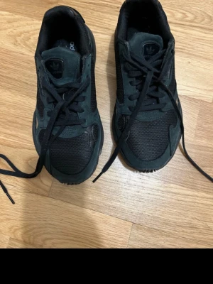 Svarta Adidas sneakers i mesh och mocka - Säljer ett par svarta Adidas sneakers med ovandel i mesh och mockadetaljer. Skorna har klassisk låg profil, svarta snören och diskret Adidas-logga på plösen. Perfekta för dig som gillar stilrena och sportiga skor.
