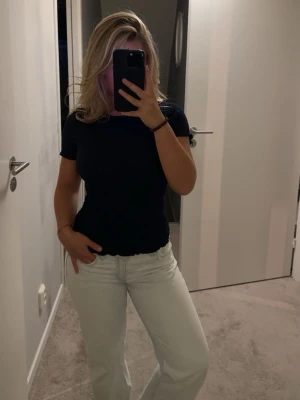 Mörkblå ribbad t-shirt - Säljer en mörkblå t-shirt med korta ärmar och rund hals från Zara. T-shirten har en stretchig, strukturerad yta som ger en cool look och sitter snyggt på kroppen. Perfekt till jeans eller kjol för en enkel men stilren outfit.🥰🥰