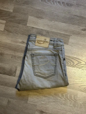 Jacob Cohen jeans  - Säljer ett par ljusgråa jeans från Jacob Cohen. Det är i väldigt bra skick förutom vid fickorna på innersidan där den är sönder se sista bilden för tydligare bild av skadan. Men det går lätt att fixa. Kontakta mig vid fler frågor och funderingar 