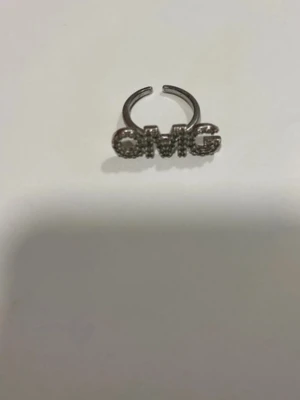OMG ring ioaku - Cool ring i silverfärg med texten 'OMG' framtill. Bokstäverna är dekorerade med små glittrande stenar, tror den e från IOAKU
