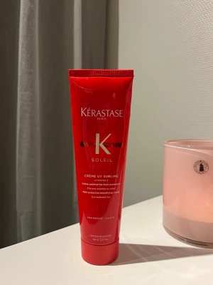 Kérastase Soleil Creme UV Sublime - Röd tub med Kérastase Soleil Creme UV Sublime, en hårkräm med vitamin E som skyddar håret mot solens strålar. En kräm för dig som vill skydda håret mot solen under sommaren. Innehåller 150 ml och har en smidig förpackning. Det finns ungefär 100 ml kvar då jag har använt den några gånger. Se på sista bilden hur mycket det är kvar. Det behövs ytters lite produkt för hela håret 
