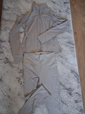 Beige/ljus grå träningsset från Primark - Säljer ett träningsset från Primark. Är i storlek M, men passar även dig som bär S.