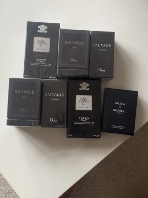 Parfymer - Försöker bli av med flera parfymer som är kopior av originalen. Dior Sauvage Elixir och Eau de Parfum i svarta rektangulära flaskor, Creed Aventus i elegant svart och silver design samt Bleu de Chanel i stilren svart förpackning. Alla förpackningar är moderna och lyxiga, perfekta för dig som gillar klassiska dofter.  Parfymerna kan antingen köpas alla samtidigt för 250kr styck eller en i taget för 400. Priset kan diskuteras över en snabb affär.