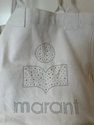 Vit totebag Marant - Vit totebag från Isabel Marant, den är medium stor och får plats med en dator och lite kläder, den har ett litet hål ned till som inte syns, skriv för bilder🥰 
