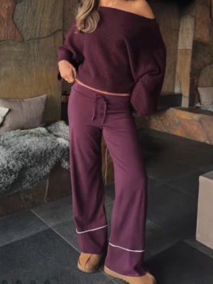 Vinröd pyjamas med vida byxor - Mysig vinröd pyjamas med vida byxor och dragsko i midjan. Byxorna har vita detaljer vid bensluten. Matchande linne med smala axelband och vit kant upptill. Perfekt för avslappnade kvällar hemma.