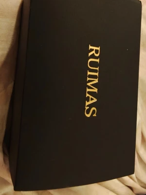 RUIMAS  - Säljer en ganska unik klocka RUIMAS! med geometriskt mönster på urtavlan. Boetten är guldigt med skruvdetaljer och har en oktagonal form. Svart armband i silikon eller gummi. Klockan levereras i originalförpackning.