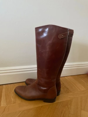 Bruna läderstövlar - Bruna stövlar i läder med låg klack. Dessa stövlar är sååå snygga att ha till shorts, kjolar, klänningar eller under jeans så ja.. snygga till i princip allt😫En sån här sko är ett måste i varje garderob då den höjer varje outfit och passar till det mesta🥳Frakt ingår ej i priset