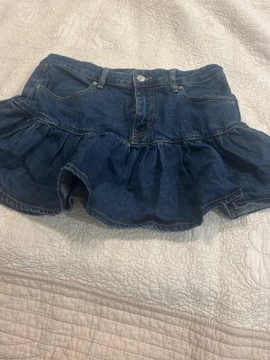 Volangkjol i denim - Snygg jeanskjol med volang. Perfekt för en trendig och avslappnad look. Lågmidjad. Säljer då den är för stor för mig. Pris går att diskuteras.