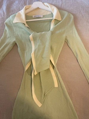 Klänning från  Adoore - Superfin långklänning från Adoore. Har en knytning på framsidan och ett formgivande mönster. Endast använd ca 2 gånger. Kommer från ett djur och rökfritt hem! 